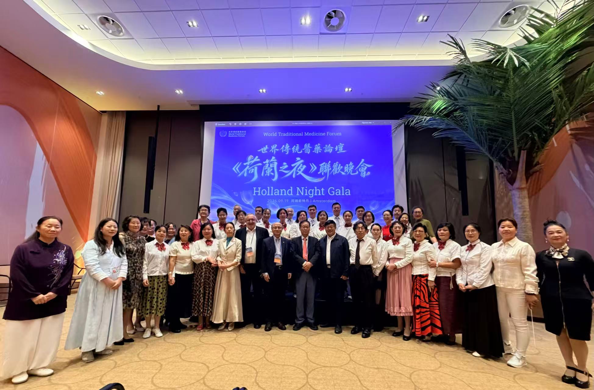 A group of people standing in front of a screenDescription automatically generated