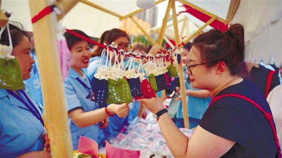 6月26日傍晚,中医药夜市吸引市民前来咨询体验。